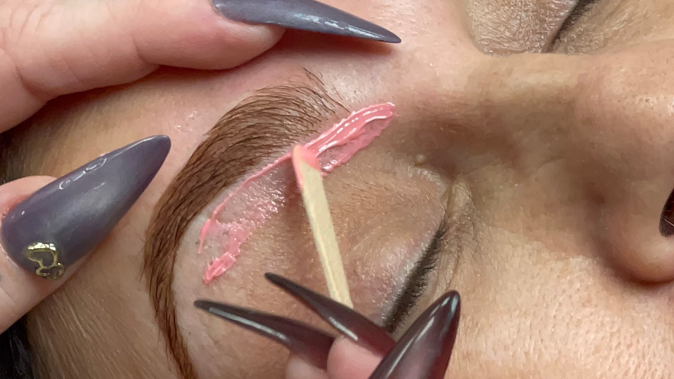Close-up of a person getting eyebrow waxing.