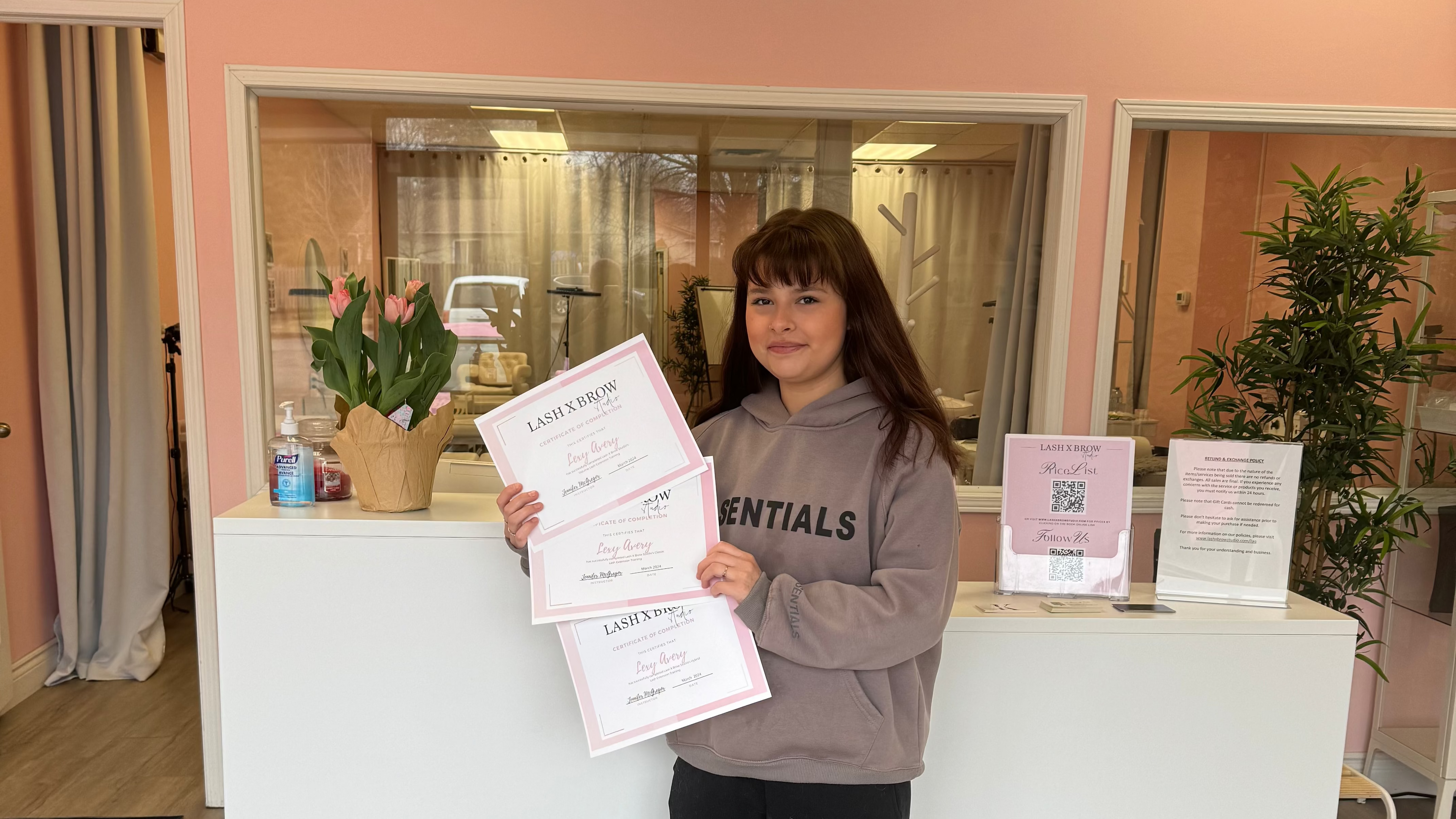 Student holding up her lash extensions certificate