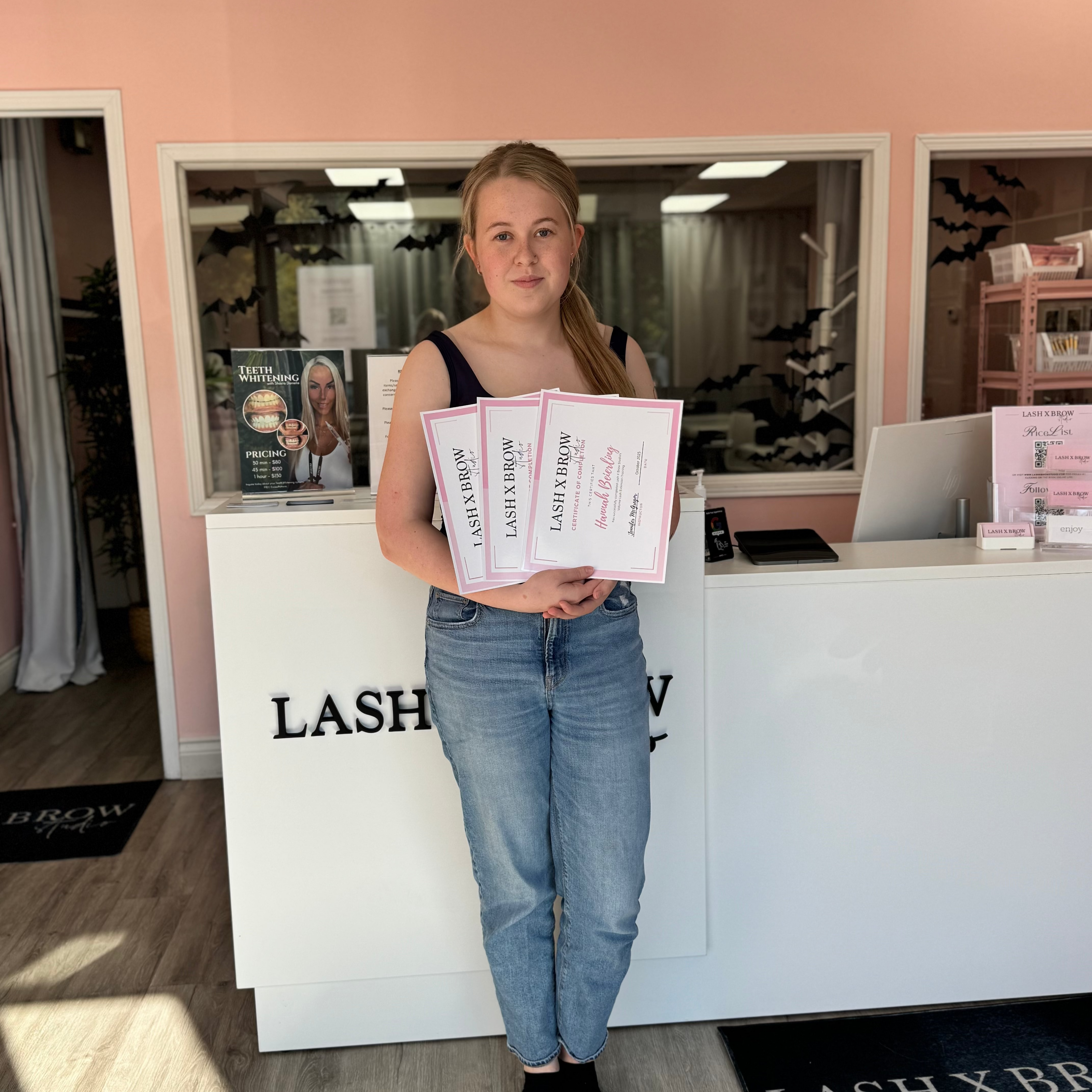 Student holding lash certificates